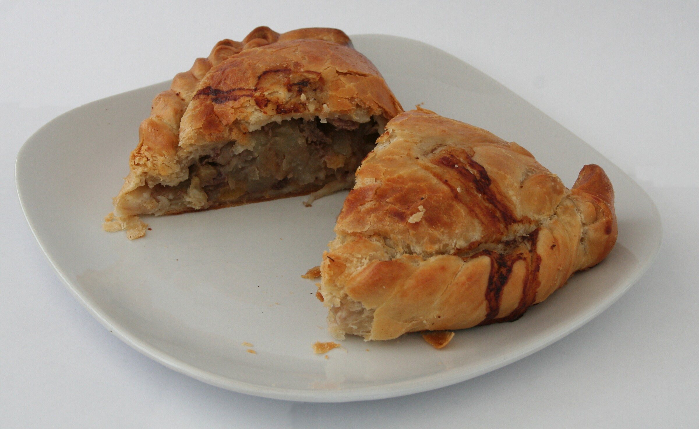 A Cornish pasty cut open to show the beef and vegetable filling