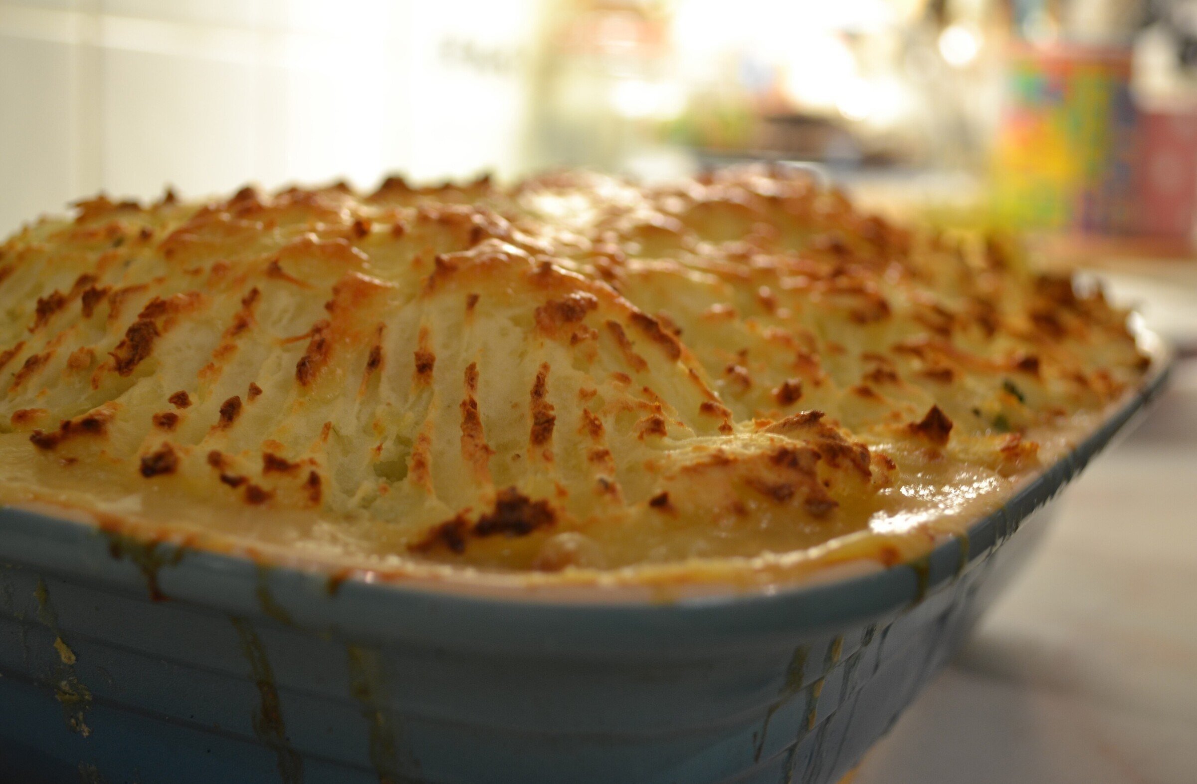 A fish pie with a golden mashed potato topping in a baking dish